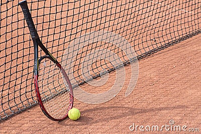 Tennis racket and balls on the clay court
