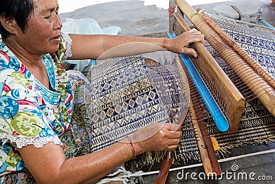 Thai woman weaving straw mat