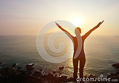 Thankful woman open arms to the sunrise