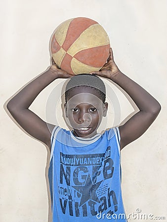 THIAROYE, SENEGAL, AFRICA – JULY 23, 2014 - Child in the street in front of a beige wall, popular district of Guinaw Rails