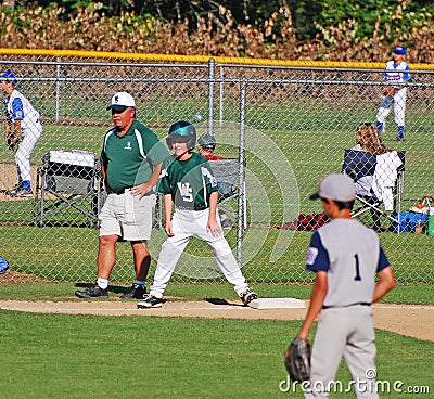 Third base coach. with boy on base.