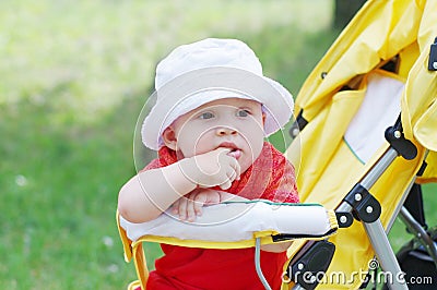 Thoughtful lovely baby age of 9 months on baby buggy