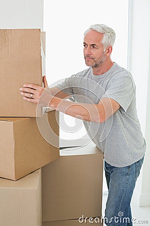 Thoughtful man looking at cardboard moving boxes