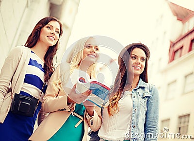 Three beautiful girls with tourist book in city