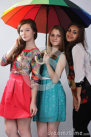 Three beautiful girls, under one umbrella. .