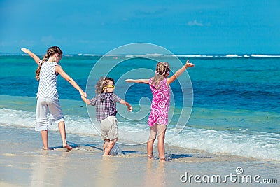 Three children standing on the beach