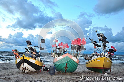 Three color boats an sea coast before the storm