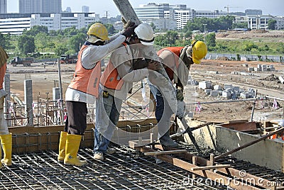 Three Construction Workers Using Hose from Concrete Pump