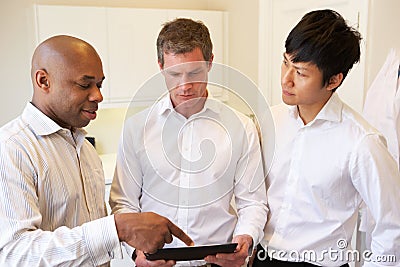 Three Doctors Having Discussion Using Digital Tablet