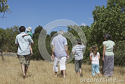 Three Generation Family Walking In Field