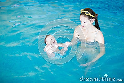 Three months baby relaxing in the swimming pool with mother