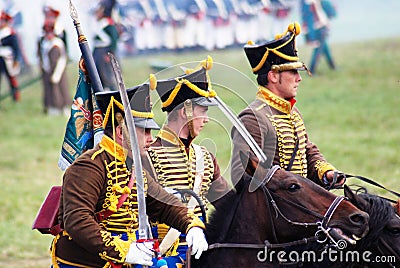 Three reenactors ride horses. Profile portrait.