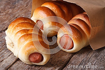Three roll with sausage close up in a paper bag