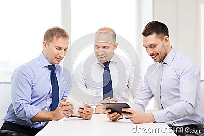 Three smiling businessmen with tablet pc in office