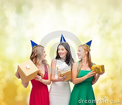 Three smiling women in blue hats with gift boxes