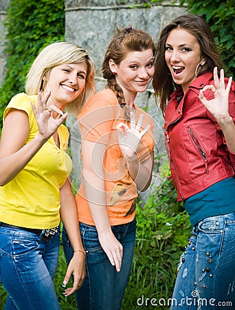 Three smiling women showing okey