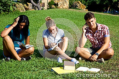 Three students in park working