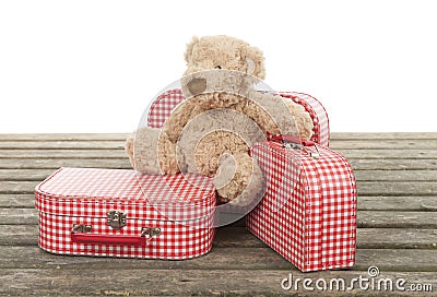 Three vintage red and white suitcases with teddy bear