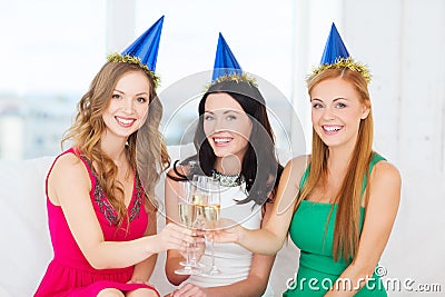 Three women wearing hats with champagne glasses