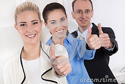 Thumbs up: businessman and two businesswoman - success.