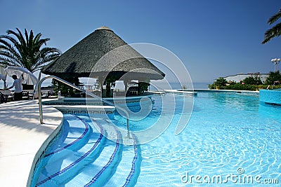 Tiki hut and bar by swimming pool of luxury hotel