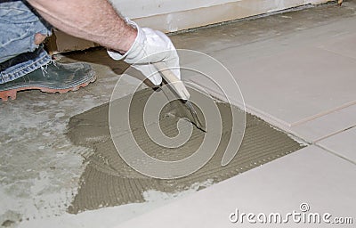 Tiler spreading tile adhesive on the floor