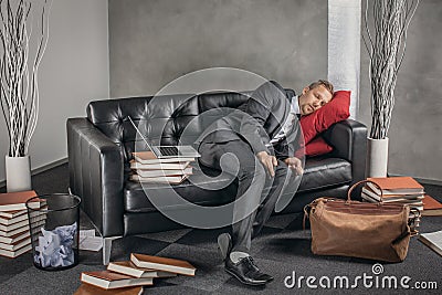 Tired businessman sleeping on the couch