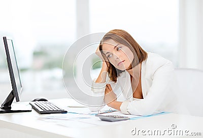 Tired businesswoman with computer and papers