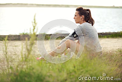 Tired Female Runner Sitting on Grass