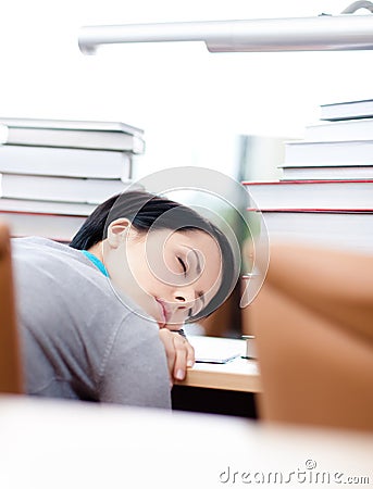 Tired female student sleeps at the table