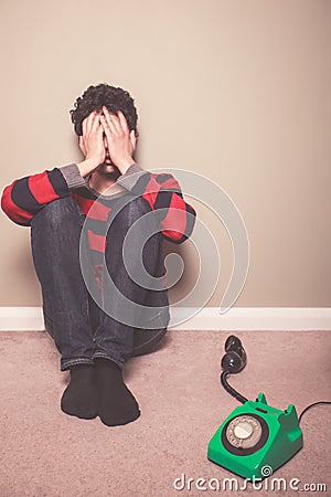 Tired and sad man on floor with telephone