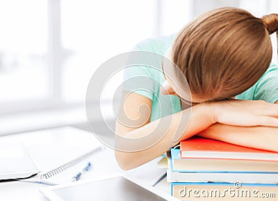 Tired student sleeping on stock of books