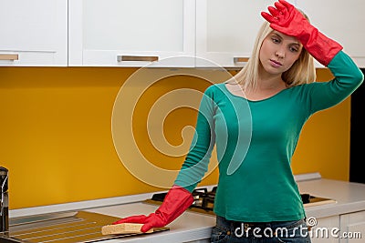 Tired woman cleaning kitchen