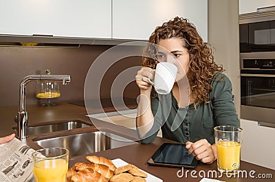 Tired young girl with cup of coffee in a breakfast