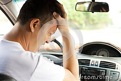 Tired young man have a headache while driving car