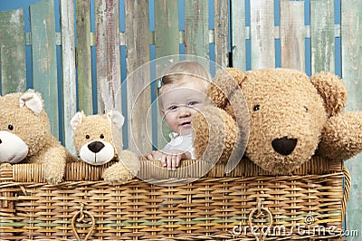 Toddler with teddy bears standing in a trunk