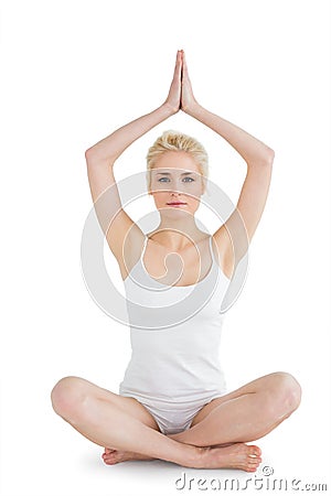 Toned young woman sitting with joined hands over head