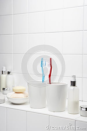 Toothbrushes face to face on shelf in white bathroom