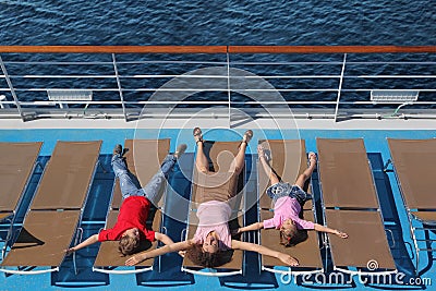 Top view of family lying at deck-chair on ship