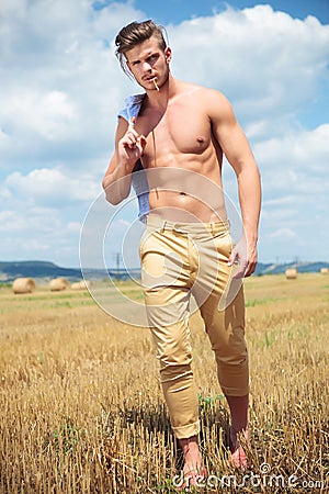 Topless man outdoor walking with straw in mouth