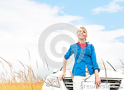 Tourist woman in front of car in summer field.