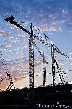 Tower Cranes In Silhouette On Construction Site