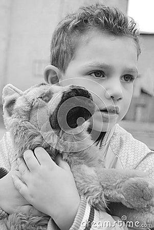 Toy favorite, black and white photo.Boy holding a toy dog