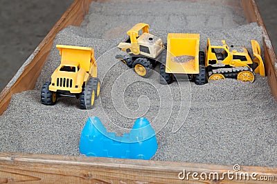 Toys in a Wooden Sandbox.