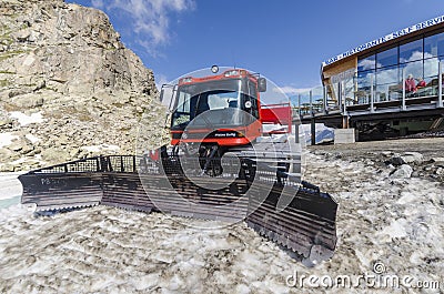 Tractor cleaning snow on the ski slopesto the top of the mountain at an altitude of 2400 meters in the Alps