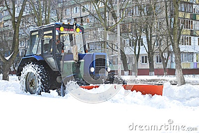 Tractor cleans snow on the street