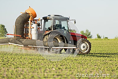 Tractor spraying soybean crops field