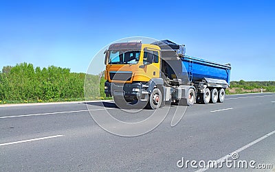 A Tractor Trailer Truck with tipper semi-trailer on the road out of town