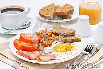 Traditional English breakfast with fried eggs, bacon and beans