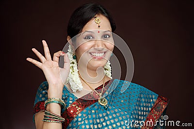 Traditional young Indian woman making OK sign